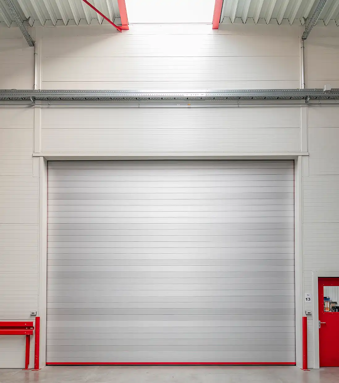 LM LINE Aluminium-Rolltor von BUCHELE in einer Industriehalle mit roten Führungsschienen