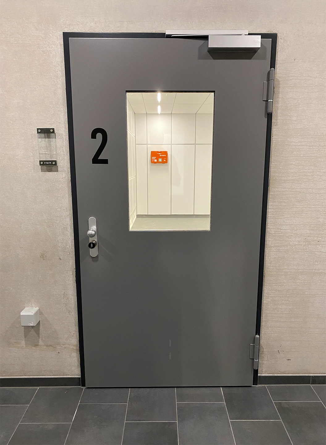 Graue Stahltür von BUCHELE mit Sichtfenster in einem Flur