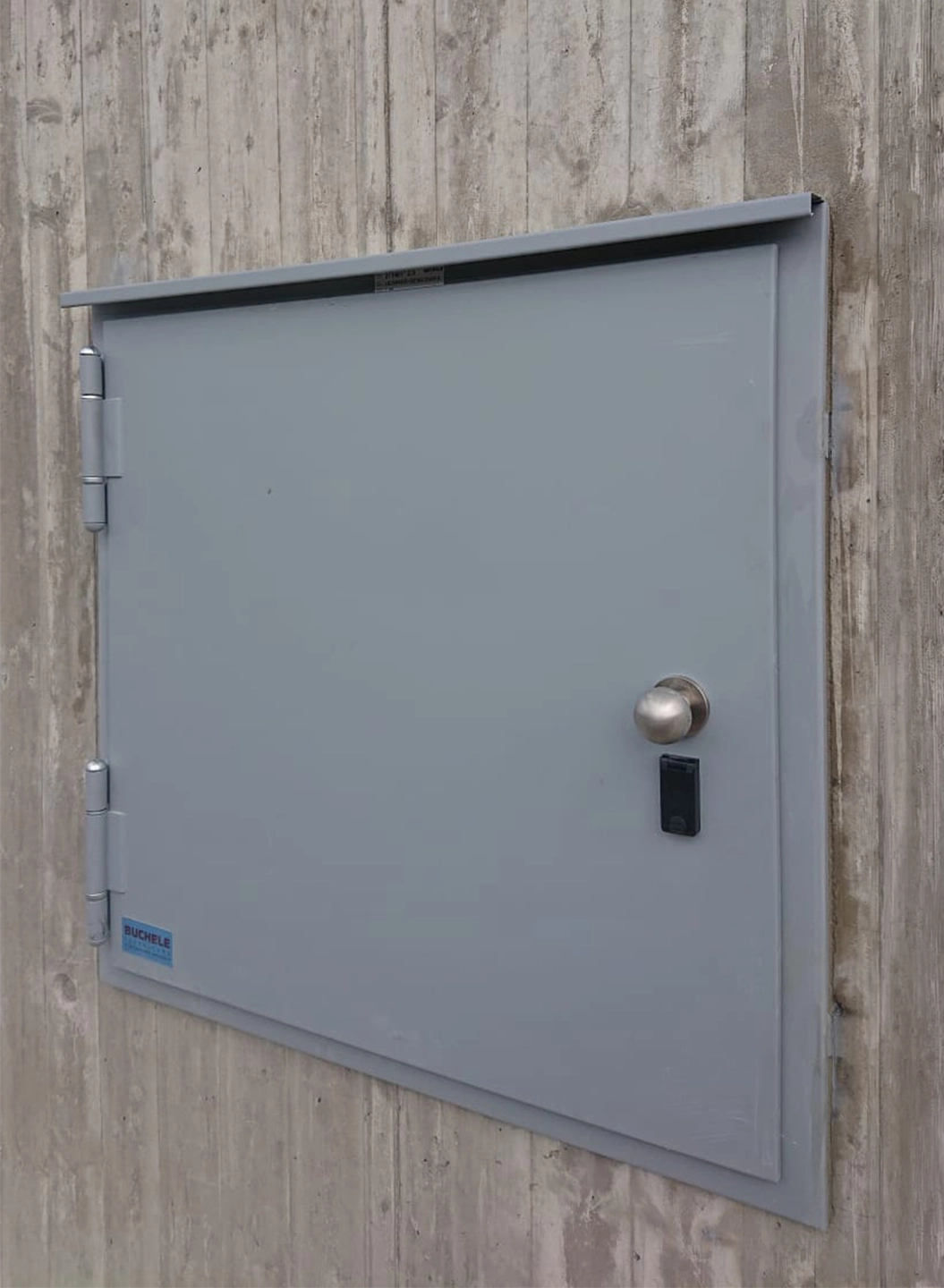 Graue Sicherheitstür von BUCHELE in Sichtbetonwand