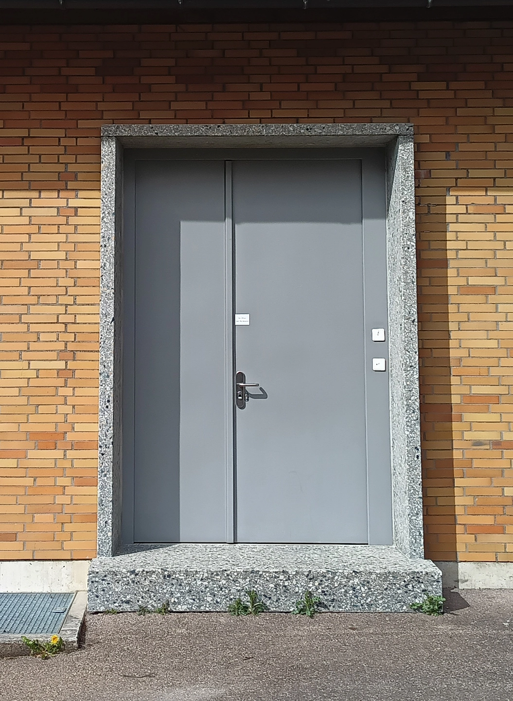 Graue zweiflügelige Sicherheitstür von BUCHELE in einer Klinkerfassade
