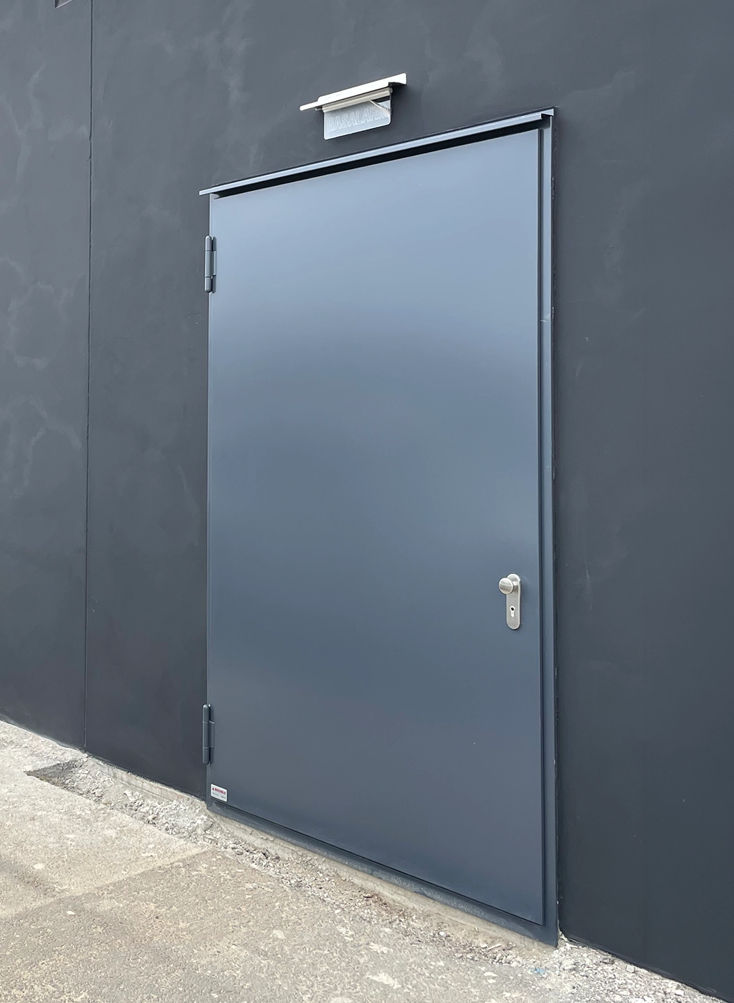 Anthrazitfarbene Stahltür von BUCHELE mit Obentürschließer in dunkler Fassade