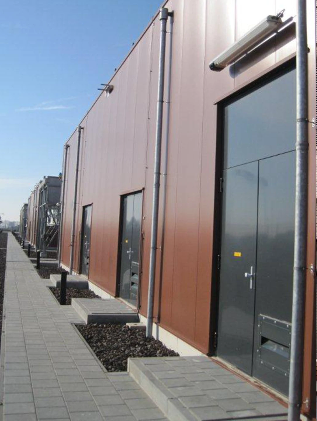 Anthrazitfarbene Stahltür in der Metallfassade eines Wasserwerks