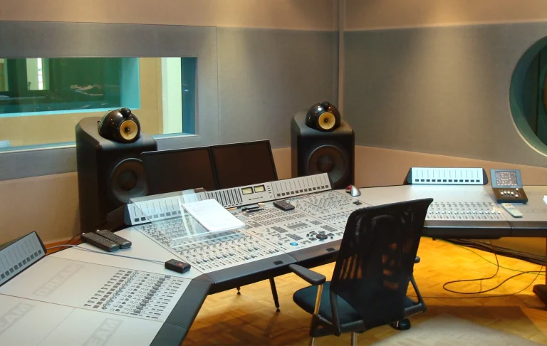 Tonstudio-Regieraum mit Mischpult, Monitoren und Schallschutzfenster