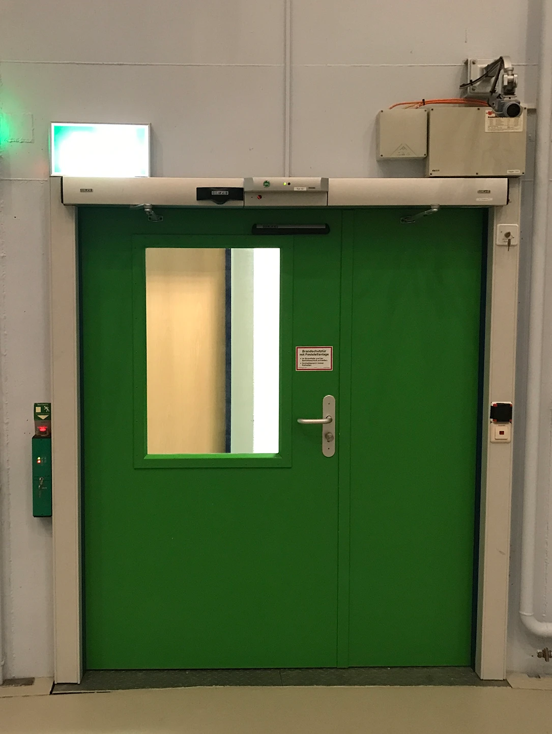 Grüne Brandschutztür von BUCHELE mit Sichtfenster und automatischem Türschließer