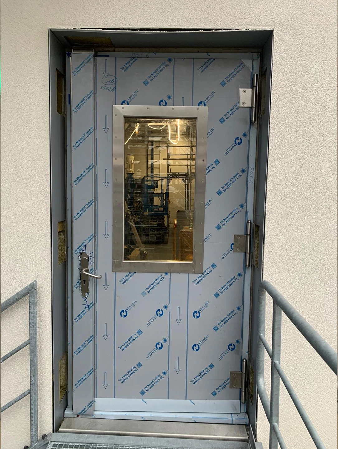 Druckbeständige Tür von BUCHELE mit Sichtfenster, noch mit Schutzfolie, an einem Außenzugang