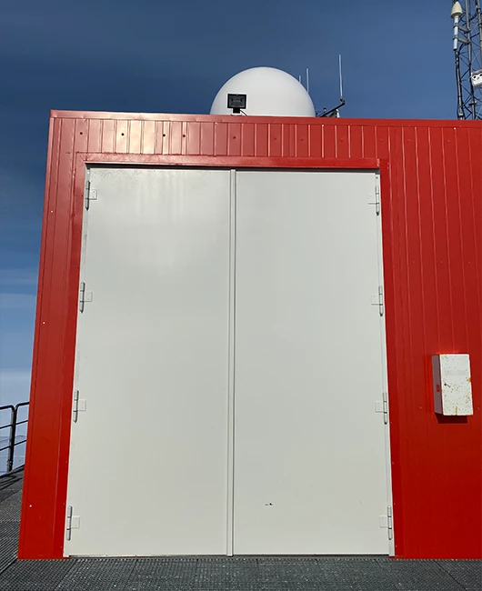 Weißes zweiflügeliges Tor von BUCHELE in der roten Fassade der Neumayer-Station III