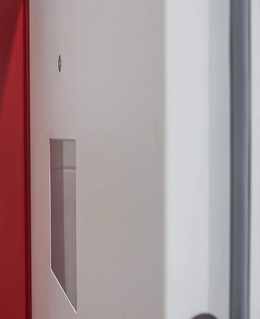 Detail einer Hafttür mit Beobachtungsklappe und roter Zarge