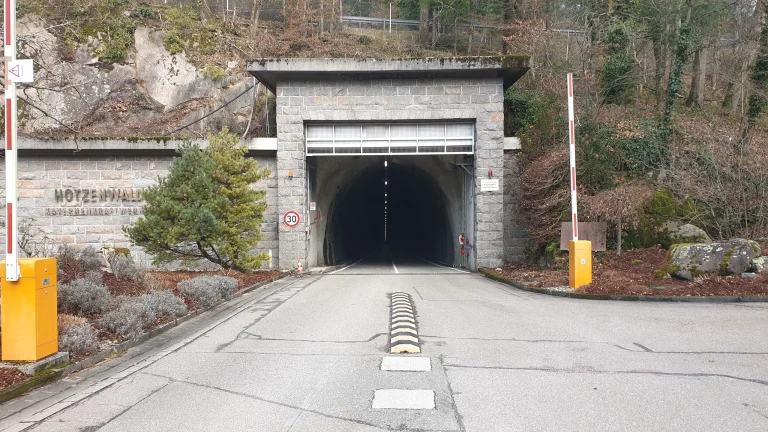 Tunnelportal mit Schrankenanlage an einer Straße im Fels