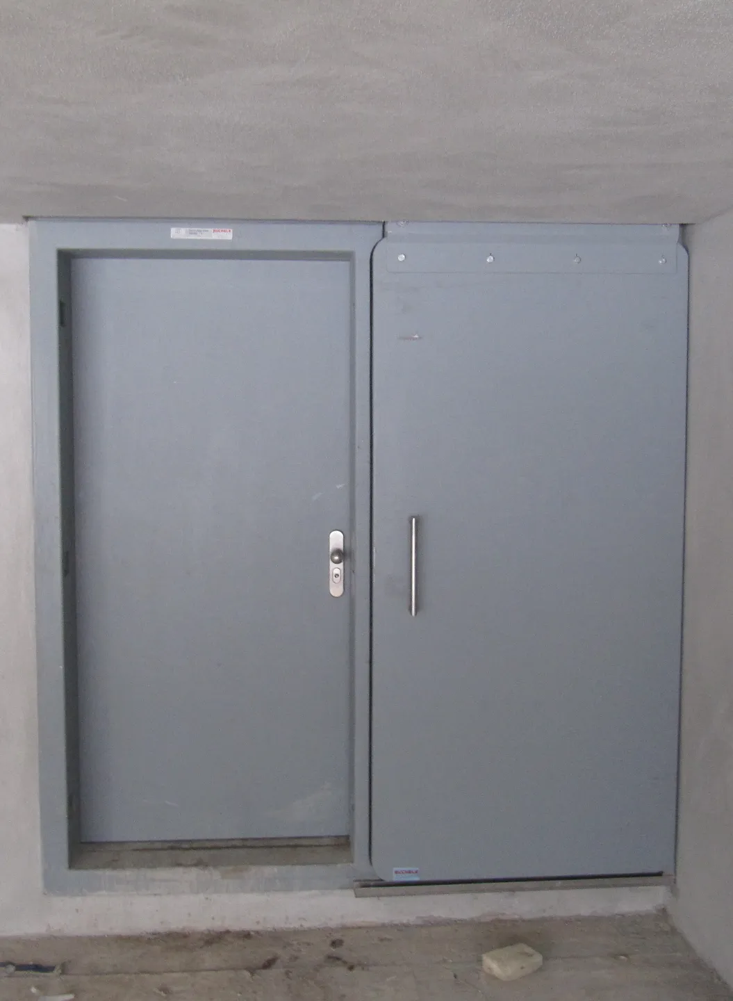 Graue Stahltür und Wandpaneel von BUCHELE in einer Betonwand eines Wasserwerks
