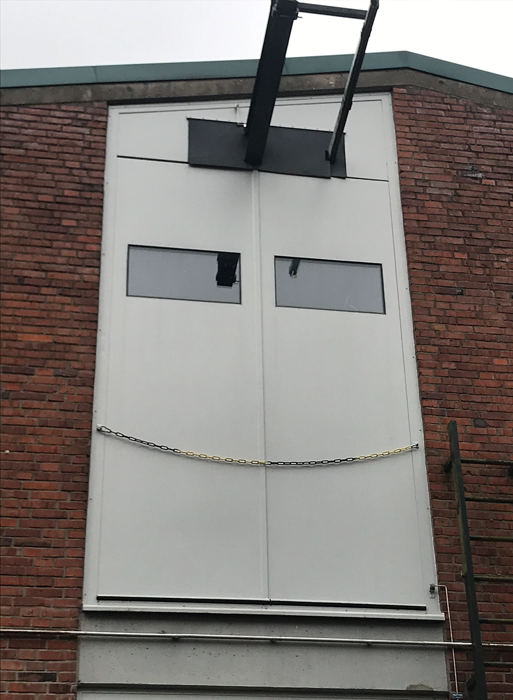 White lift gate with vision panels by BUCHELE in a brick facade