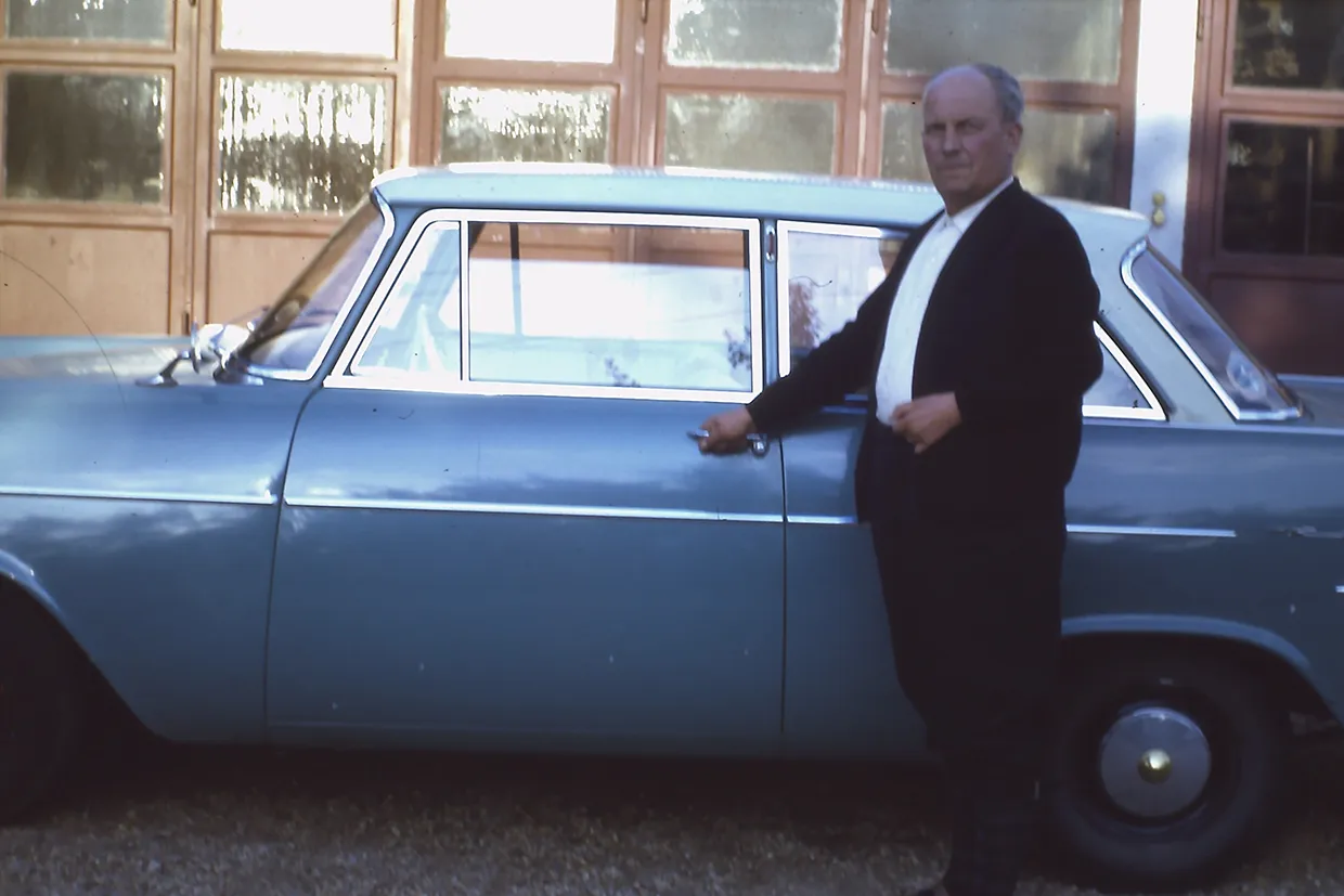 Company founder next to a blue car in front of the Buchele premises, 1968