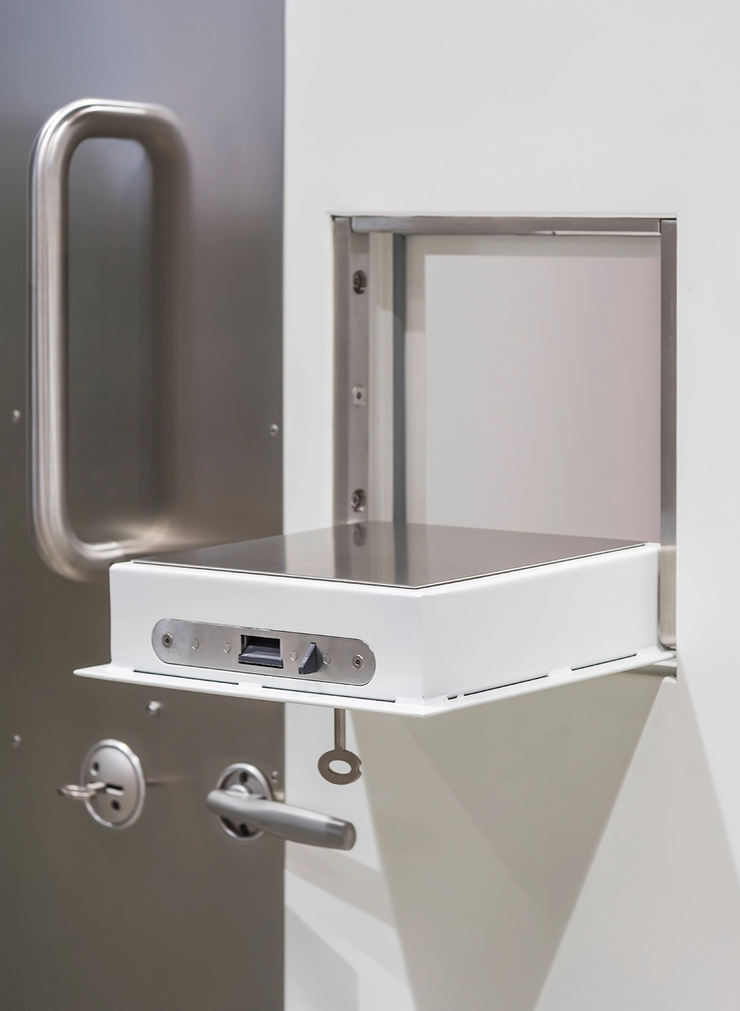 Detail of an escape-proof door: stainless steel hatch and security locks