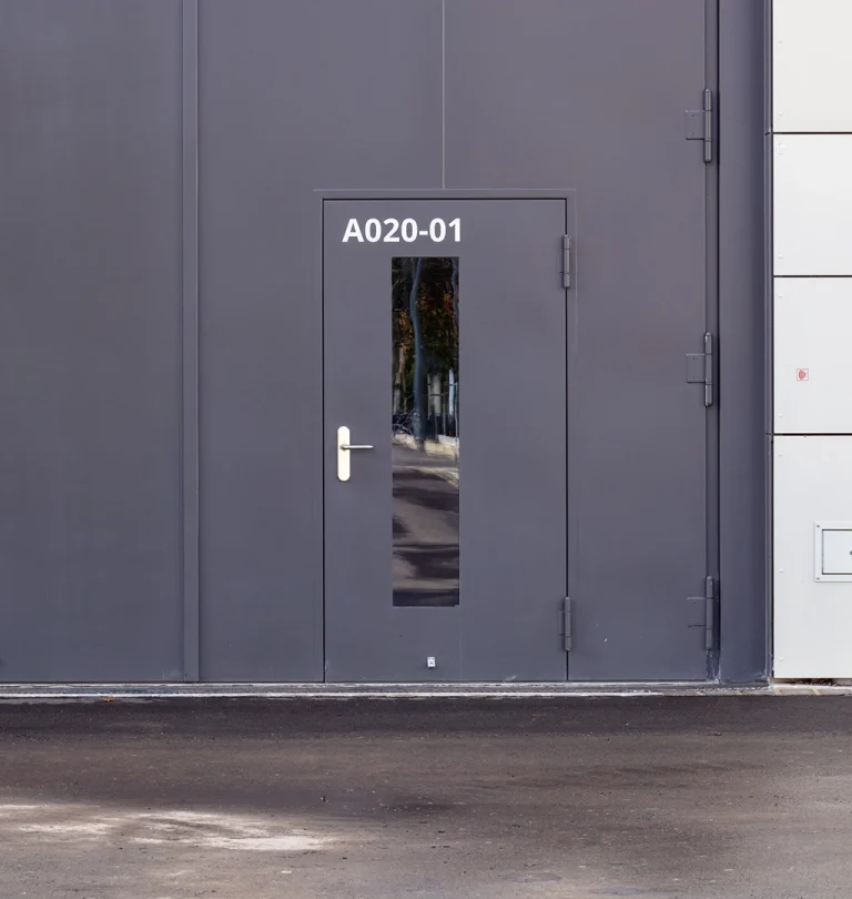 Anthracite security door A020-01 with vision panel in a metal facade