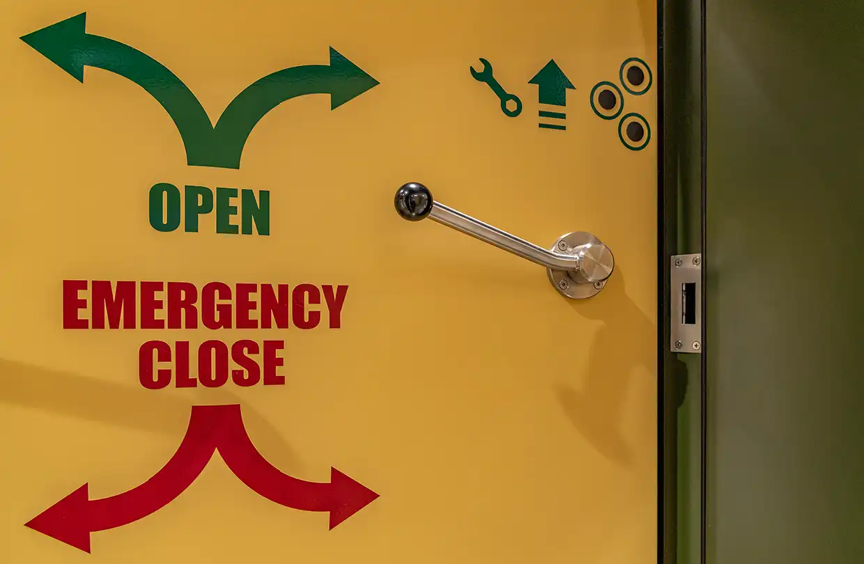 Emergency locking OPEN / EMERGENCY CLOSE on a yellow SHELTER LINE shelter door
