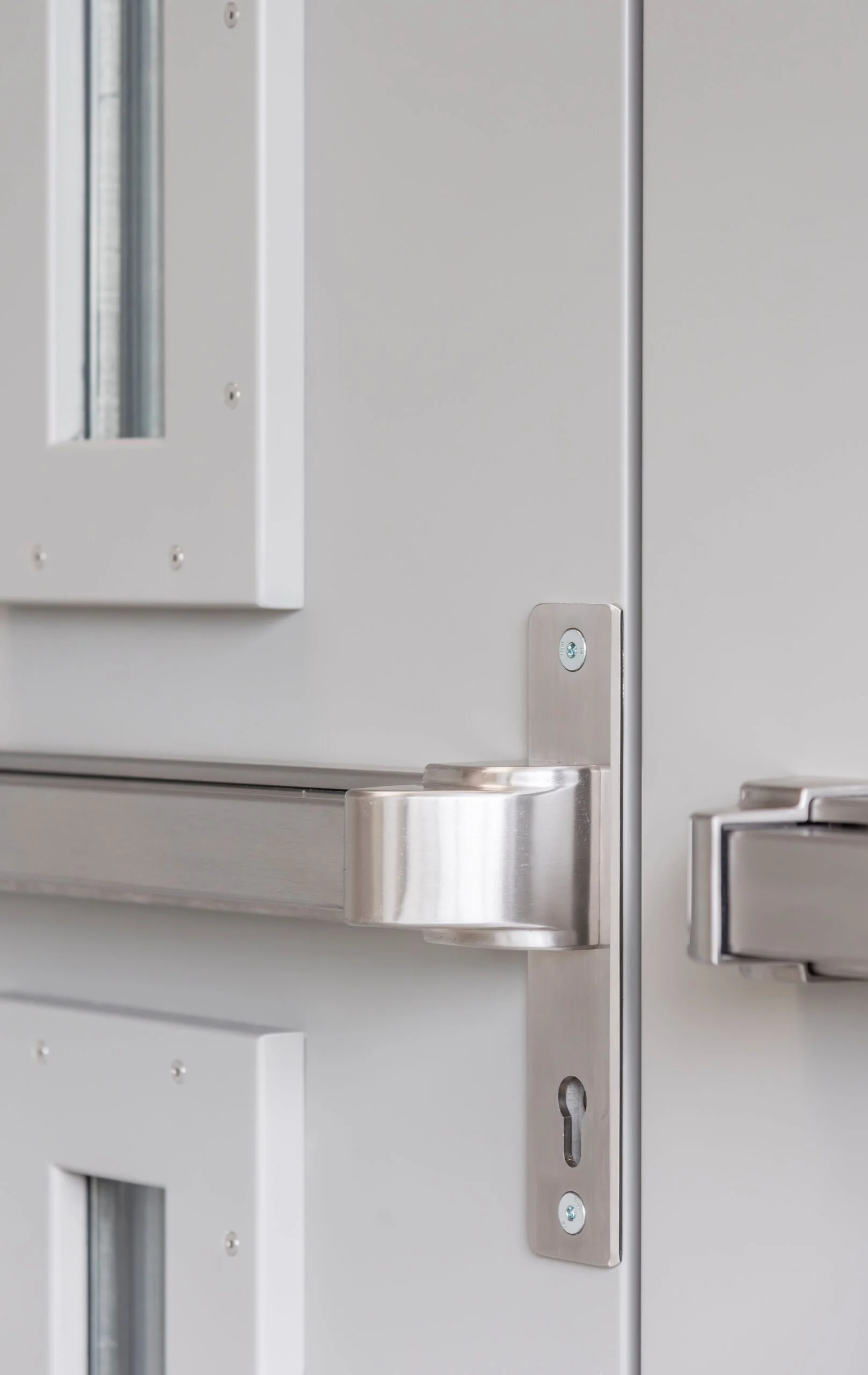 Stainless steel panic bar and fitting on a white security door