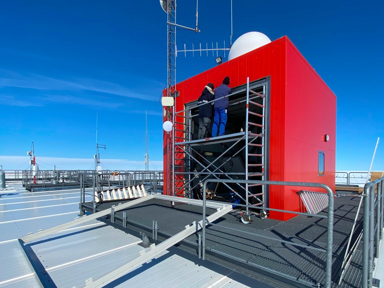 Rotes Gebäude der Neumayer-Station III in der Antarktis mit Gerüst unter blauem Himmel
