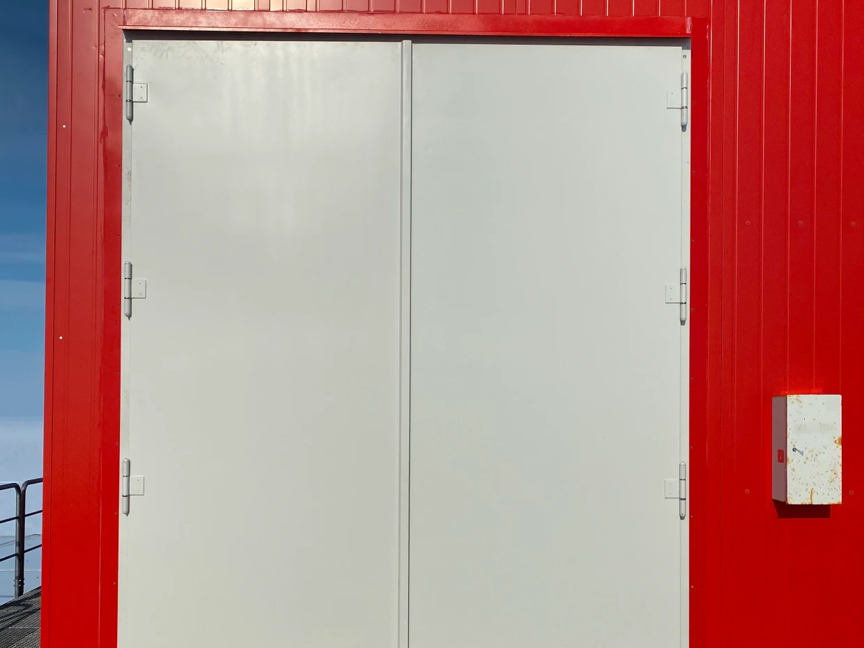 Weißes zweiflügeliges Tor von BUCHELE in der roten Fassade der Neumayer-Station III
