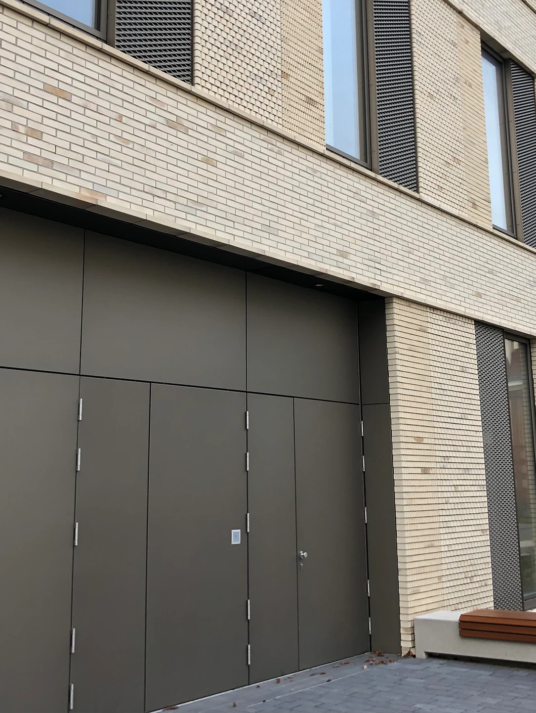 Dark grey folding gate by BUCHELE with integrated door at a data centre