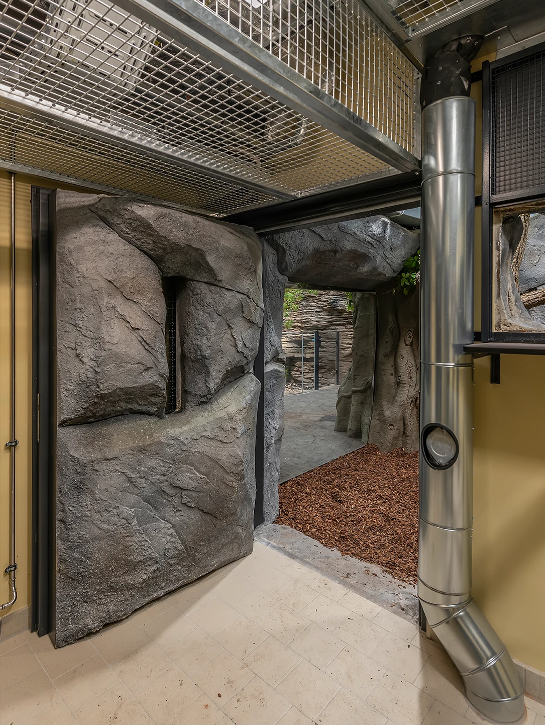 Rock-look door by BUCHELE in an animal enclosure with stainless steel ventilation pipe