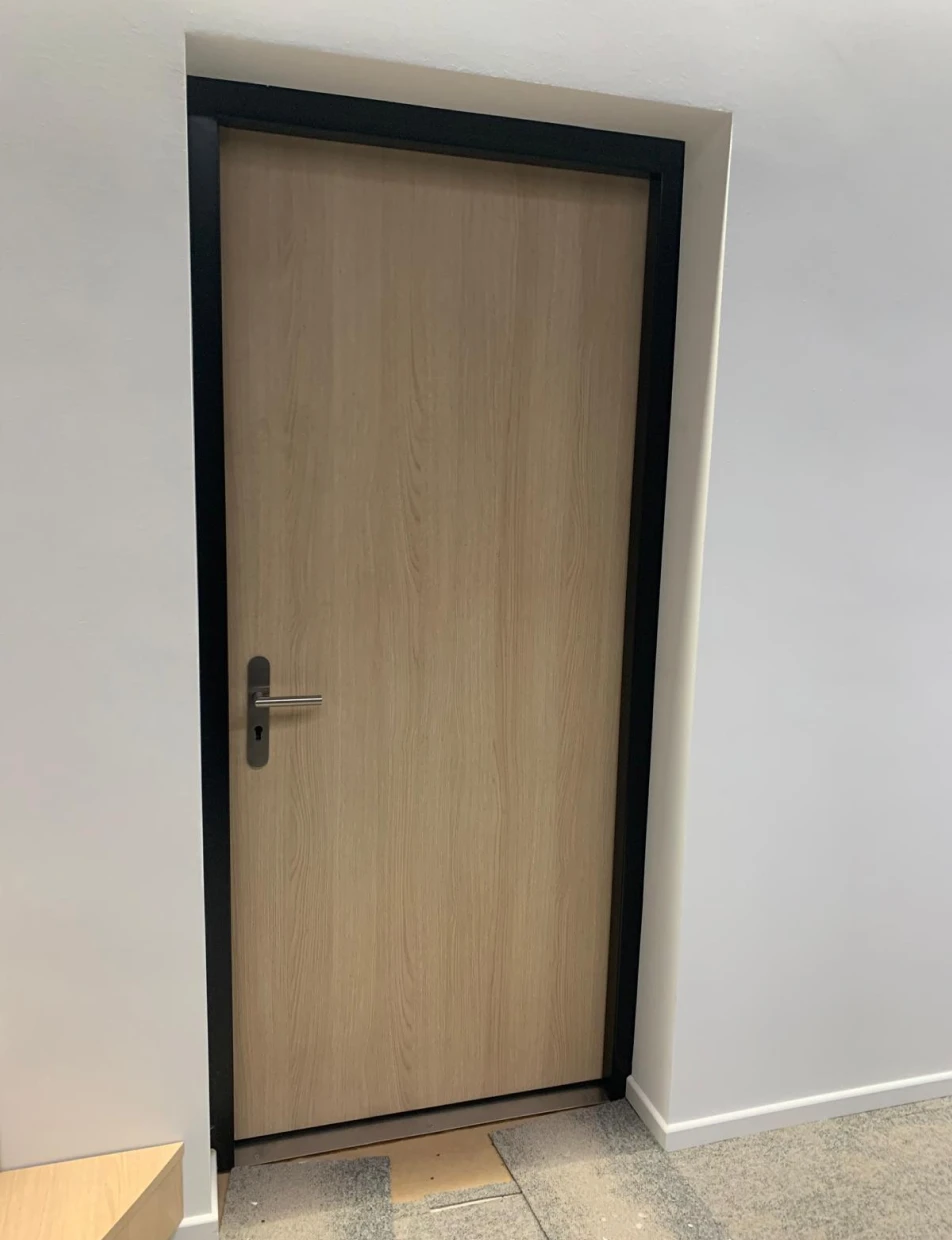 BUCHELE DELUXE Tür mit heller Holzoberfläche und schwarzer Zarge