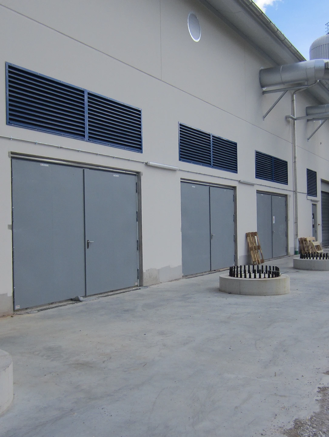 Double-leaf grey explosion protection doors with ventilation grilles on an operations building