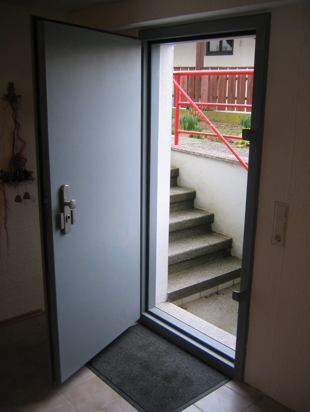 Grey flood protection door by BUCHELE with multi-point locking at a stairway